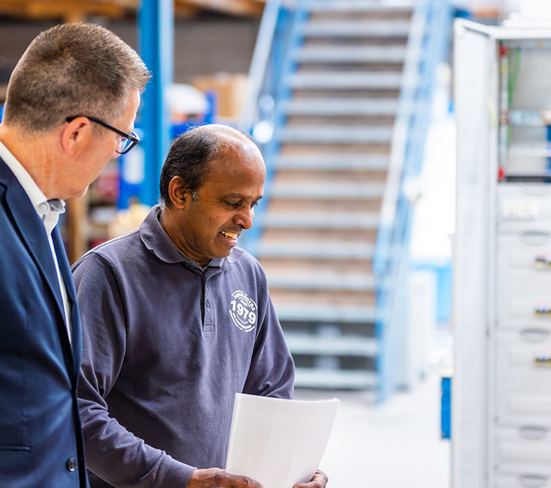Kannan aan het werk in de werkplaats, in overleg met een collega.