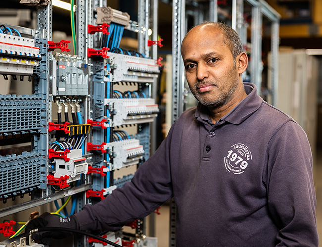 Kannan op zijn werkplek, kijkt in de camera.